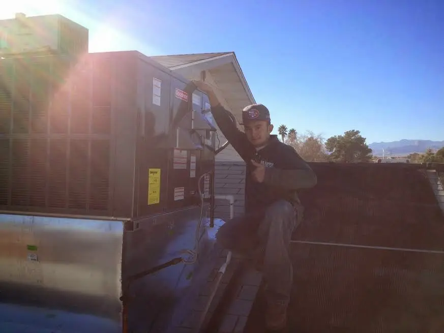 HVAC technician performing Air Duct Cleaning on a rooftop unit in Westbrook