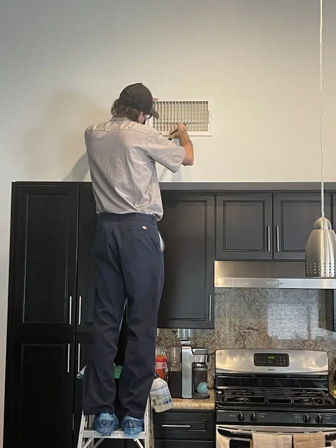 Technician inspecting an air vent during HVAC service in Westbrook